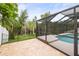 Serene outdoor pool area with beautiful tile flooring and a view of the lush greenery at 826 Addison Ne Dr, St Petersburg, FL 33716