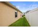 Side yard showcases green grass and a white privacy fence leading to the backyard at 826 Addison Ne Dr, St Petersburg, FL 33716
