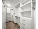 Bright walk-in closet boasts carpet flooring, recessed lighting, and white built-in shelving and storage at 826 Addison Ne Dr, St Petersburg, FL 33716