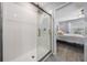 Bathroom featuring a sleek glass-enclosed shower and a glimpse into the Primary bedroom at 8310 Hardy Bay Loop, Wesley Chapel, FL 33545