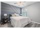 Bedroom with a unique accent wall, ceiling fan and wood-look flooring at 8310 Hardy Bay Loop, Wesley Chapel, FL 33545