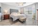 Bright bedroom featuring a large window, ceiling fan, and a comfortable bed with stylish linens at 8310 Hardy Bay Loop, Wesley Chapel, FL 33545