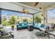 Inviting screened-in patio with comfortable seating, ceiling fans, and a view of the landscaped backyard at 8310 Hardy Bay Loop, Wesley Chapel, FL 33545