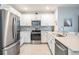Bright kitchen featuring stainless steel appliances, white cabinetry, and granite countertops at 8310 Hardy Bay Loop, Wesley Chapel, FL 33545
