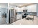 Well-lit kitchen featuring stainless steel appliances, white cabinetry, and mosaic backsplash at 8310 Hardy Bay Loop, Wesley Chapel, FL 33545
