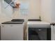 Functional laundry area features a washer and dryer with an overhead storage shelf at 8310 Hardy Bay Loop, Wesley Chapel, FL 33545
