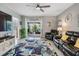 Comfortable living room features a ceiling fan, stylish rug, and a sliding glass door to the patio at 8310 Hardy Bay Loop, Wesley Chapel, FL 33545