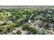 Aerial view displays home among lush landscaping in a quiet neighborhood, with the golf course in the backdrop at 8499 101St Ave, Seminole, FL 33777