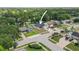 Aerial view shows home with red mulch landscape bed, mature trees, and neighborhood with golf course in background at 8499 101St Ave, Seminole, FL 33777
