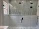 Modern bathroom with a glass shower, grey tiles, black fixtures, and a window at 904 Grand Canyon Dr, Valrico, FL 33594