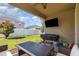 Covered back patio featuring a ceiling fan, TV, grill, and outdoor furniture with a view of the backyard at 11711 Winterset Cove Dr, Riverview, FL 33579