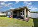 Exterior shot of the back of the house showcasing a covered patio and well-maintained lawn at 11711 Winterset Cove Dr, Riverview, FL 33579