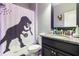 Whimsical bathroom with granite countertop, dinosaur shower curtain and vanity lighting at 11711 Winterset Cove Dr, Riverview, FL 33579
