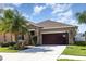 Beautiful home with palm trees, manicured lawn, and a two-car garage at 11711 Winterset Cove Dr, Riverview, FL 33579