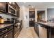 Well-equipped kitchen features granite countertops, stainless steel appliances, and dark wood cabinetry at 11711 Winterset Cove Dr, Riverview, FL 33579