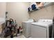 Functional laundry room with washer, dryer, and shelving for organized storage at 11711 Winterset Cove Dr, Riverview, FL 33579