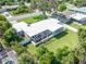 Beautiful home with a large manicured lawn, an outdoor deck, perimeter fencing, and tropical landscaping at 120 Crestwood Ln, Largo, FL 33770