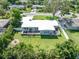 Backyard aerial view featuring a large yard, screened porch, and landscaping at 120 Crestwood Ln, Largo, FL 33770