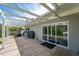 An outdoor wooden patio features seating, a grill, and a covered pergola to enjoy the backyard view at 120 Crestwood Ln, Largo, FL 33770