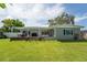 Beautiful backyard with a large grassy area, a deck, and a covered pergola perfect for outdoor living at 120 Crestwood Ln, Largo, FL 33770