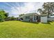 Exterior view featuring a spacious green backyard with a large patio and a white privacy fence at 120 Crestwood Ln, Largo, FL 33770