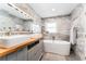 Elegant bathroom featuring double sinks, marble walls, and a freestanding bathtub at 120 Crestwood Ln, Largo, FL 33770