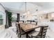 Elegant dining area with a modern chandelier, large wooden table, and adjacent open kitchen at 120 Crestwood Ln, Largo, FL 33770