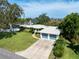 Well-kept home with vibrant landscaping, paved driveway, and charming blue garage doors at 120 Crestwood Ln, Largo, FL 33770