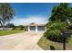 Beautiful single-story home with a long concrete driveway, two-car garage and lush landscaping, providing great curb appeal at 120 Crestwood Ln, Largo, FL 33770