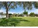 Beautiful single-story home with a large front yard, mature tree, and two-car garage at 120 Crestwood Ln, Largo, FL 33770