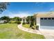 Charming single-story home featuring a well-manicured front lawn, palm trees, and an attached two-car garage at 120 Crestwood Ln, Largo, FL 33770