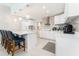 Modern kitchen featuring sleek countertops, pendant lighting, a breakfast bar, and stainless steel appliances at 120 Crestwood Ln, Largo, FL 33770