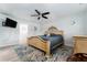 Spacious main bedroom with stylish ceiling fan and luxurious wooden frame bed with decorative rug at 120 Crestwood Ln, Largo, FL 33770