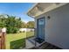 The side door of the home overlooks the green backyard lawn, with a wooden deck next to it at 120 Crestwood Ln, Largo, FL 33770