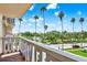 Enjoy the outdoor view from this balcony with white railings and palm trees and greenery at 1200 N Shore Ne Dr # 404, St Petersburg, FL 33701