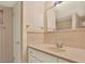 Bathroom vanity features light-colored counters, neutral wallpaper, and a large, well-lit mirror at 1200 N Shore Ne Dr # 404, St Petersburg, FL 33701