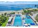 Aerial view of the community pool featuring multiple pools with ocean views and mature trees at 1200 N Shore Ne Dr # 404, St Petersburg, FL 33701