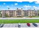 Multi-story building with a light beige exterior, complemented by manicured landscaping and palm trees at 1200 N Shore Ne Dr # 404, St Petersburg, FL 33701