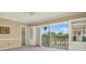 This living room features carpet, built-in shelving, and a sliding glass door leading to an outdoor view at 1200 N Shore Ne Dr # 404, St Petersburg, FL 33701