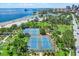 Aerial view of community tennis courts near the beach with palm trees and blue hard surface at 1200 N Shore Ne Dr # 404, St Petersburg, FL 33701