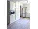 Open kitchen with stainless steel appliances, built-in microwave, shaker cabinets, and wood-look tile flooring at 1200 Tarpon Woods Blvd # M6, Palm Harbor, FL 34685