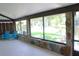 Enclosed patio features stone accents, concrete flooring and views of the backyard pond at 1200 Tarpon Woods Blvd # M6, Palm Harbor, FL 34685