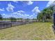 Fenced backyard with grass and view of pond and surrounding trees at 1218 Willow Bend Way, Lutz, FL 33549