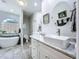 Bright bathroom features double sinks, marble countertops, a soaking tub, and tiled floors at 1218 Willow Bend Way, Lutz, FL 33549