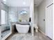Bright bathroom featuring a modern soaking tub, glass block window, and a separate glass-enclosed shower at 1218 Willow Bend Way, Lutz, FL 33549