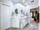 Bright bathroom featuring dual sinks with granite countertops, white cabinetry, and entry to living area at 1218 Willow Bend Way, Lutz, FL 33549