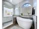 Bright bathroom featuring a modern soaking tub, glass block window, and a separate glass-enclosed shower at 1218 Willow Bend Way, Lutz, FL 33549