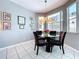 Bright dining area features tile floors, neutral paint, modern lighting, and windows overlooking yard at 1218 Willow Bend Way, Lutz, FL 33549