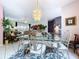 Open-concept dining area with chandelier, glass table, and view into the living room at 1218 Willow Bend Way, Lutz, FL 33549