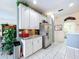 Bright kitchen features white cabinets, stainless appliances, granite countertops, and tile floors at 1218 Willow Bend Way, Lutz, FL 33549